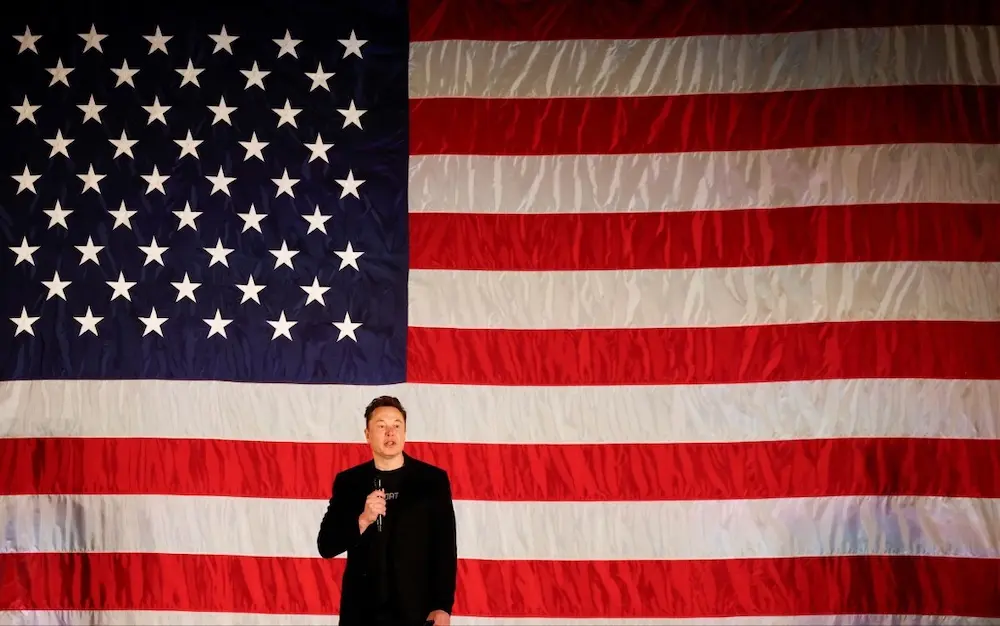 Elon Musk infront of American flag